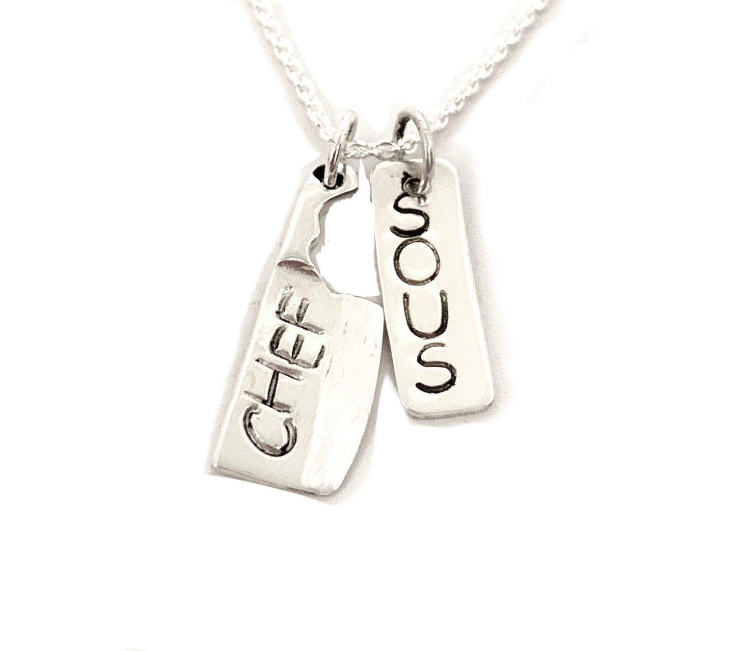 silver cleaver and dog tag stamped sous chef
