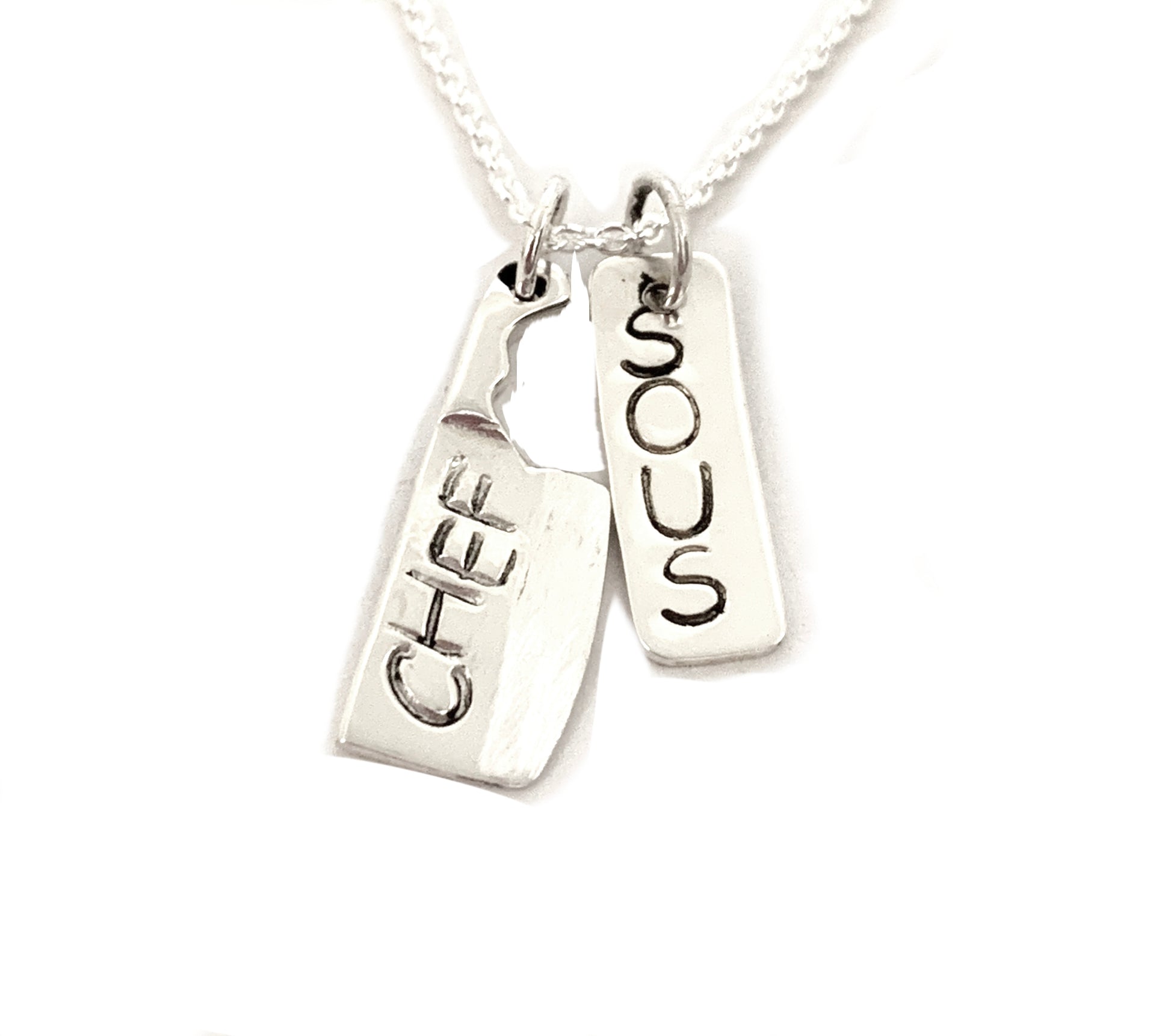 silver cleaver and dog tag stamped sous chef